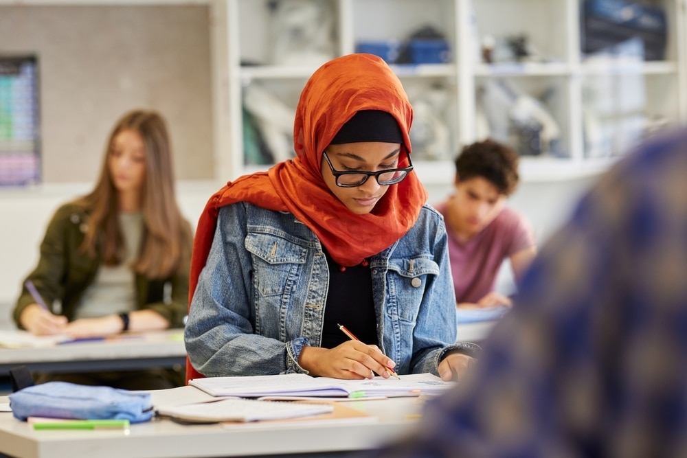 A young female writing during class.