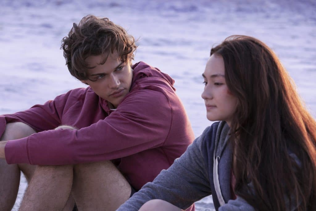 Conrad and Belly sit on beach together