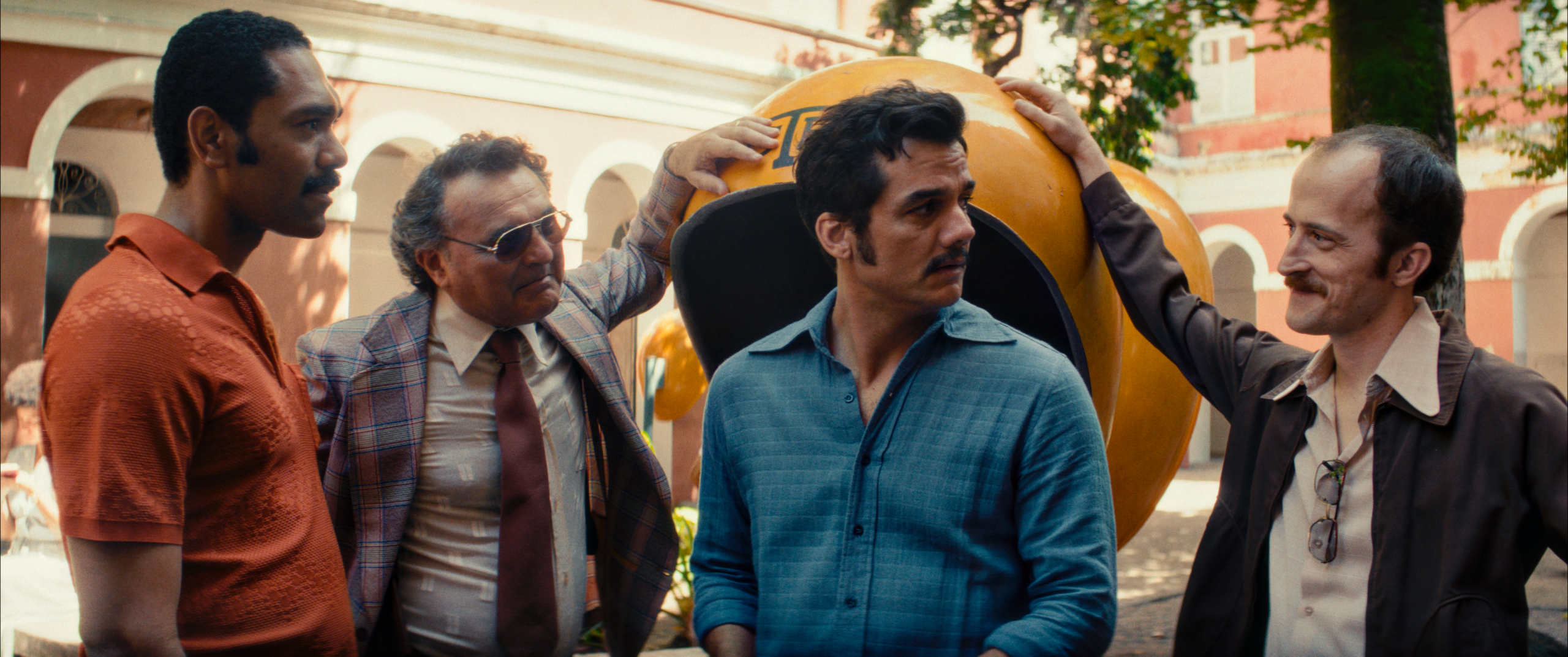 Marcelo (Wagner Moura) surrounded by policemen at a pay phone.