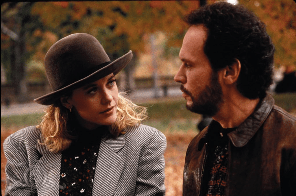 Sally looks at Harry with fall leaves in the background