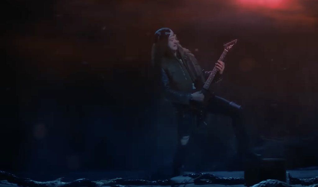 Eddie Munson playing the guitar.