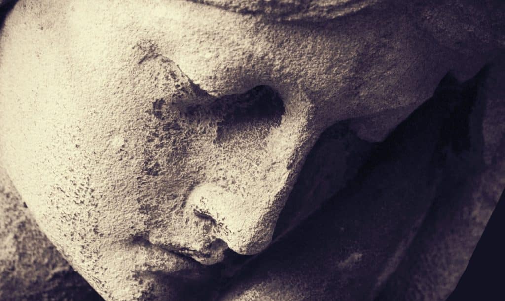 Image of a stone figure's worn face.