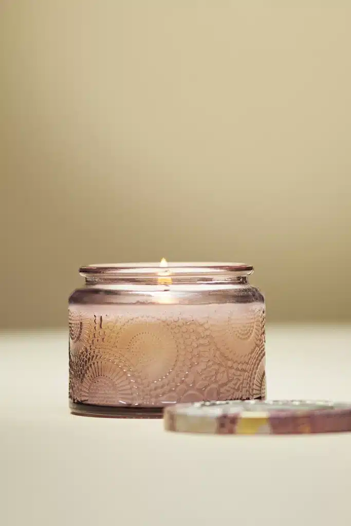 beige candle lit on beige background