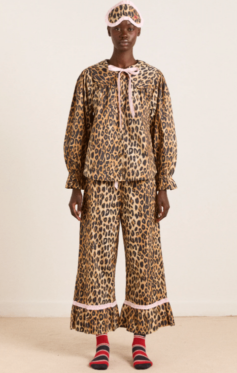 girl wearing leopard print pajamas on pink background