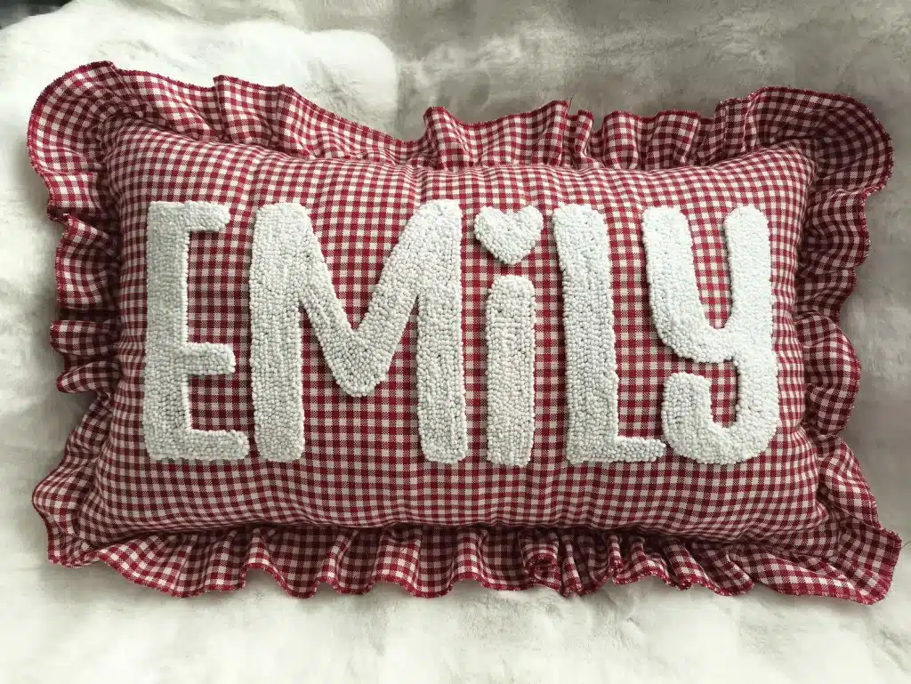 red and white gingham pillow with "emily" written across center