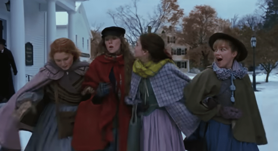 Four sisters linking arms and walking in the snow.