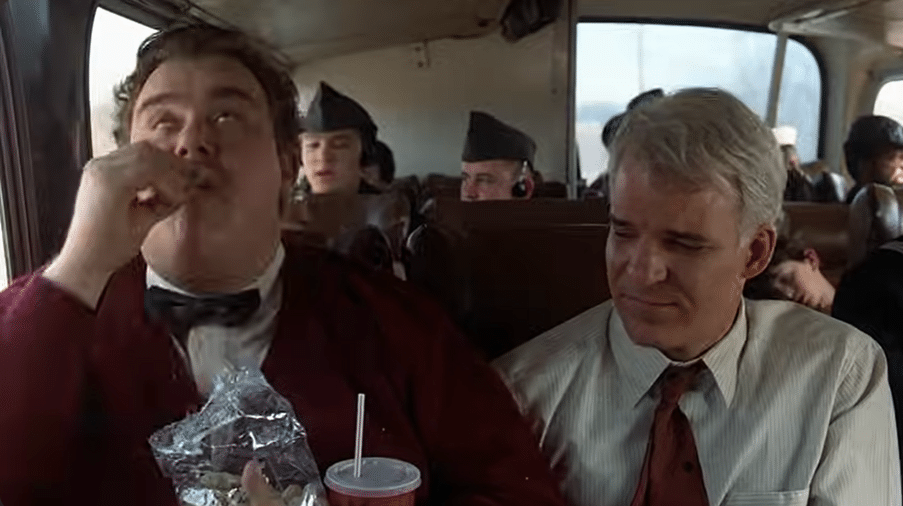 Two men sitting in their seats on a plane