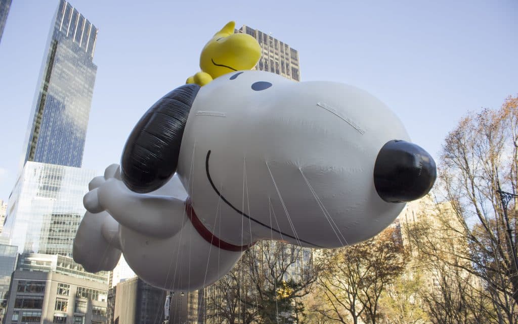 A gigantic Snoopy the cartoon beagle balloon flies through New York City.