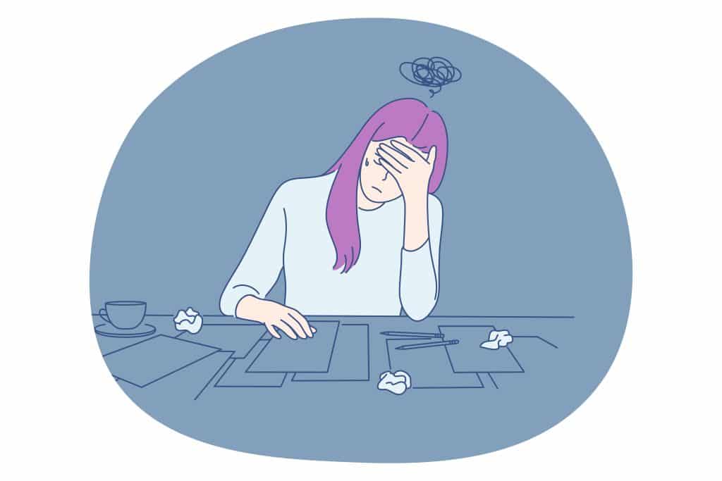 A person with their hand on their head, overwhelmed by stress, work, anxiety