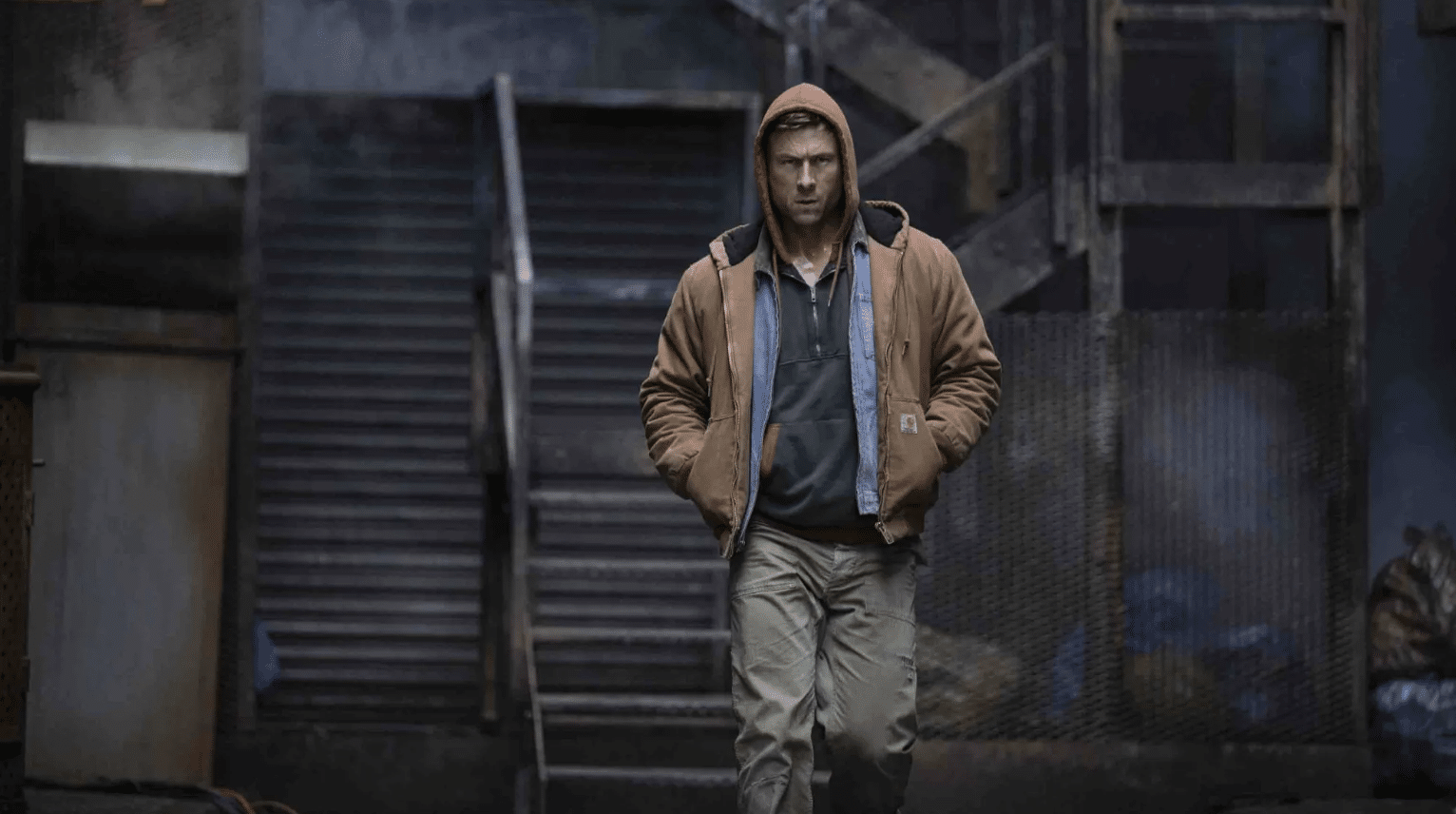 Glen Powell as Ben Richards walks down stairs in the running man