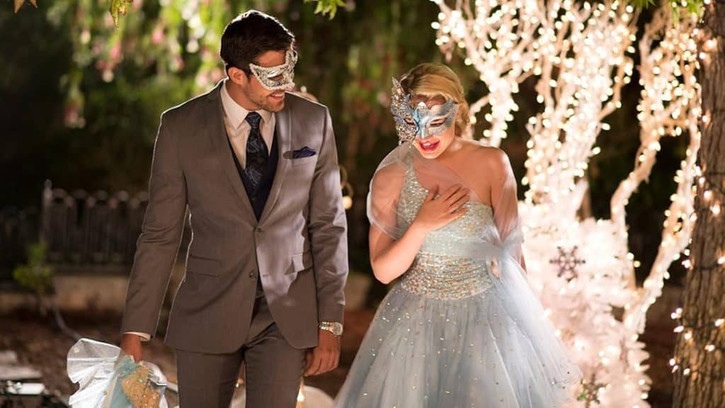 Angie and Nicholas in their formal attire and masks, laughing as they walk together.