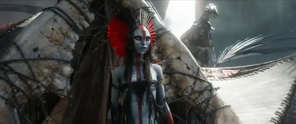 A grey, humanoid alien steps out of a tent made out of bone.