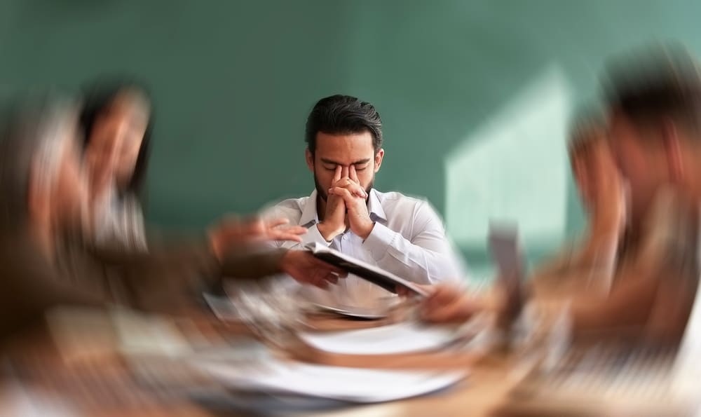 A man at a table. The edges are blurred to make it look like he is stressed.
