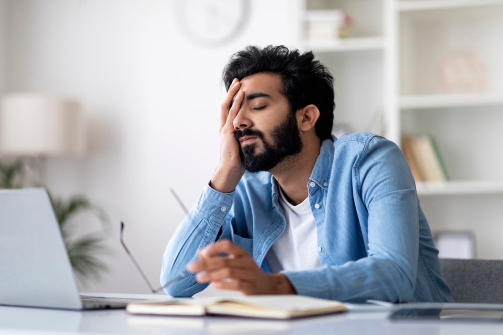A man falling asleep at his desk