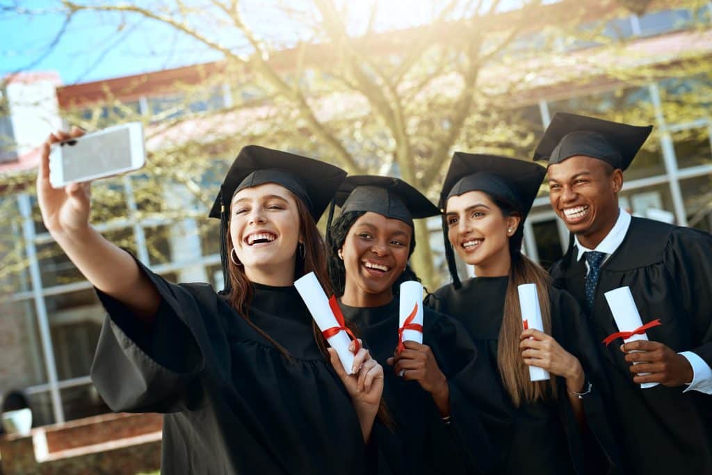 Four friends taking a selfie during graduation.