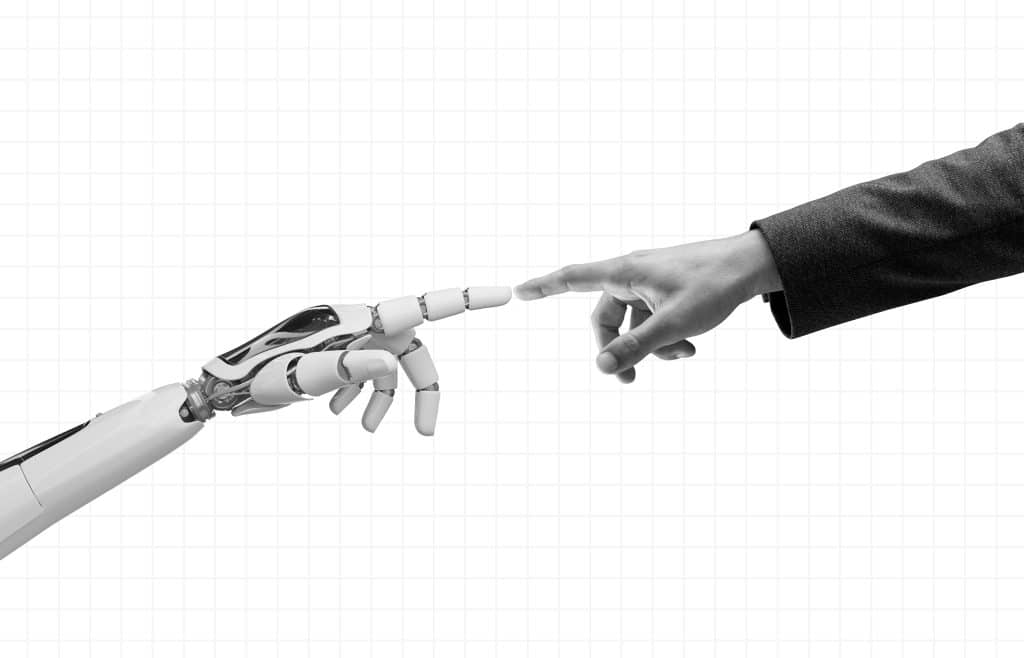 A robot hand and a human hand reaching their arms out to touch each other with one of their fingers.