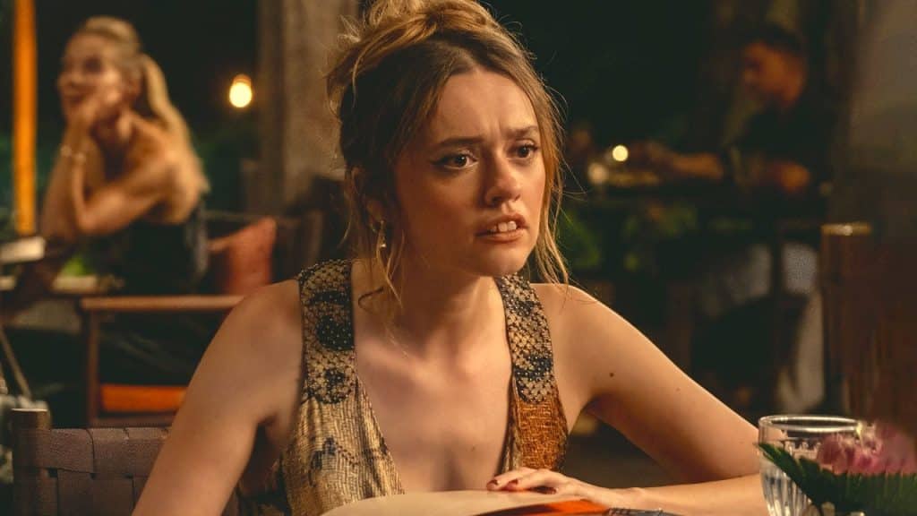 Aimee Lou Wood in Season 3 of 'The White Lotus', where she is sat at a dinner table