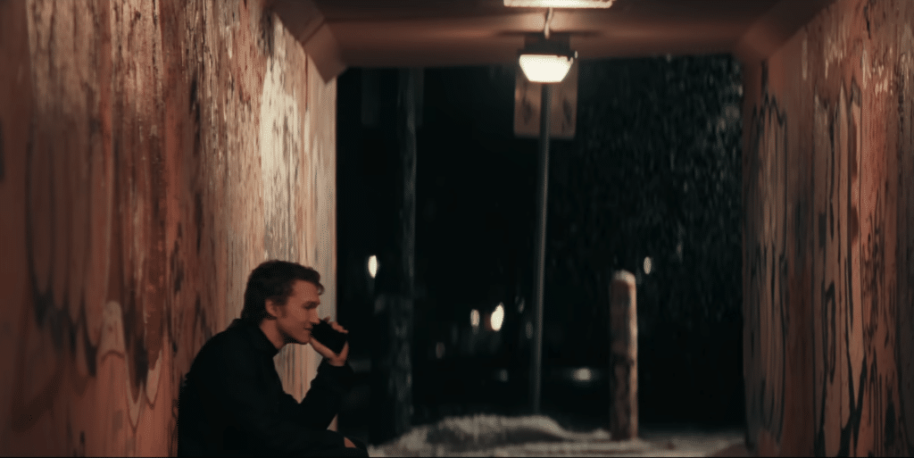 The character Ilya, under an overpass on the phone