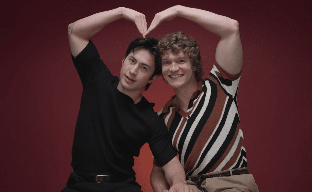 Two actors shaping their arms to make a heart