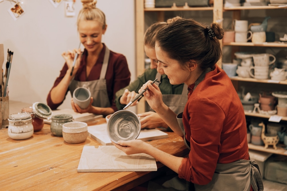 Friends making pottery together (Shutterstock/Raisa Kanareva)
