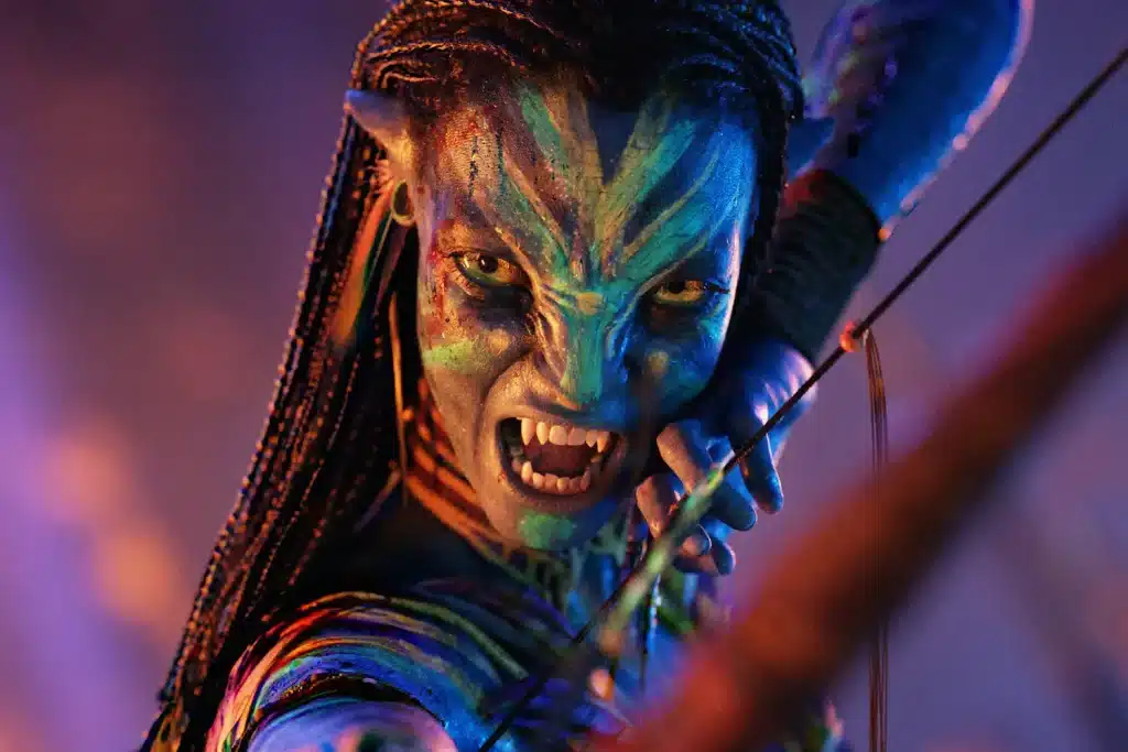 The image depicts Neytiri, a main character in Avatar, pulling back on her bow string, her face covered in war paint.