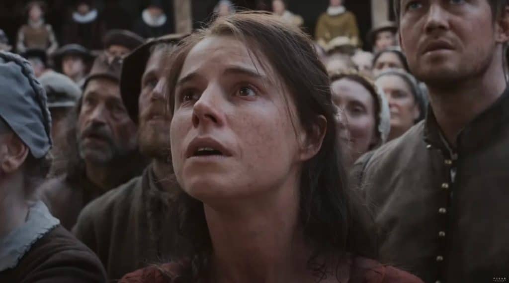 Jessie Buckley among a crowd of people in "Hamnet." (Credit: Focus Features)