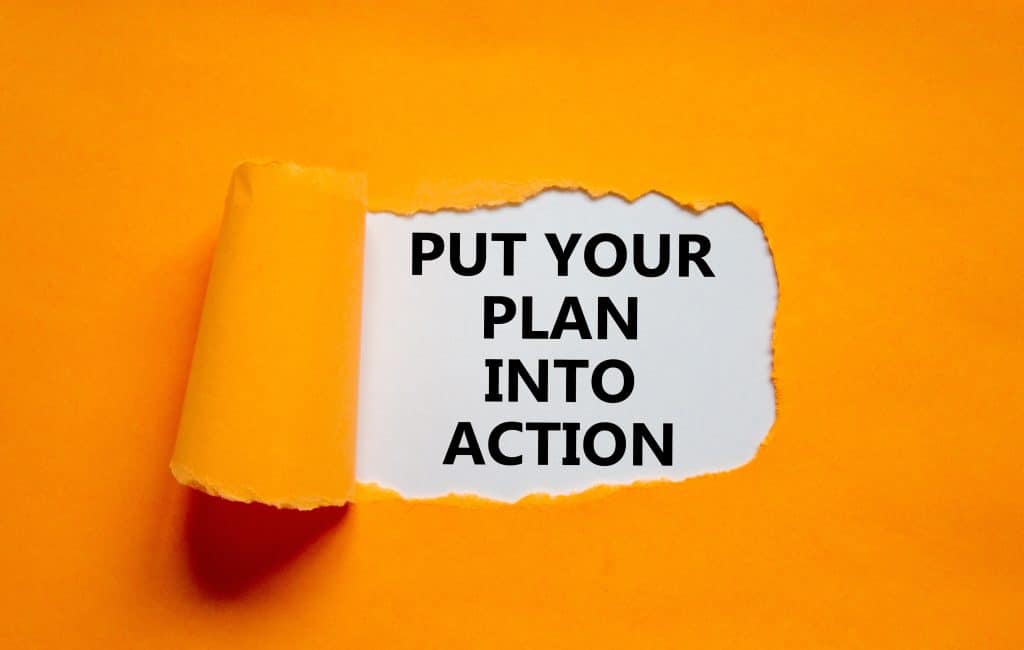 Put your plan into action symbol. Concept words Put your plan into action on white paper on a beautiful orange background. Business planning and put your plan into action concept. Copy space.