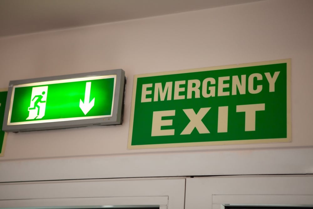 Two emergency exit signs above a door