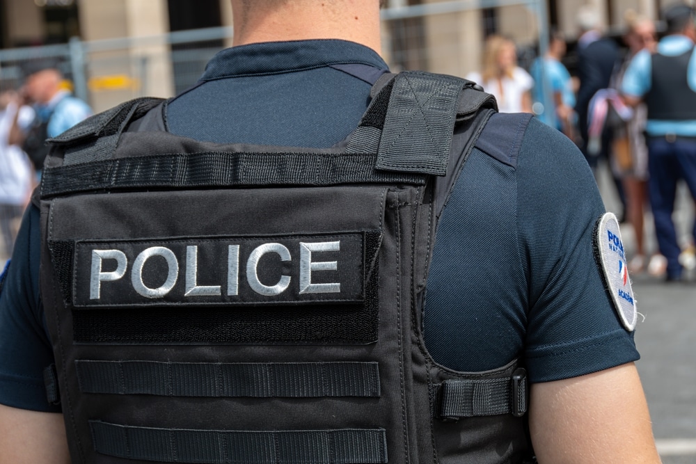 The back of a policeman in a bulletproof vest