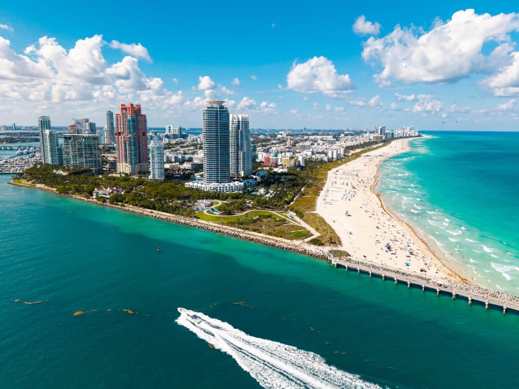 Aerial view of Miami Beach marina with turquoise waters and the South Beach skyline, June 18, 2025. The city’s luxury image often contrasts with the financial and social pressures that emerge during group trips. (Credit: Red Fox Studio/Shutterstock)