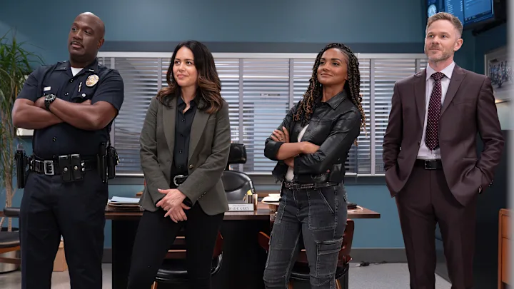 4 members of the cast of The Rookie standing and looking off screen.