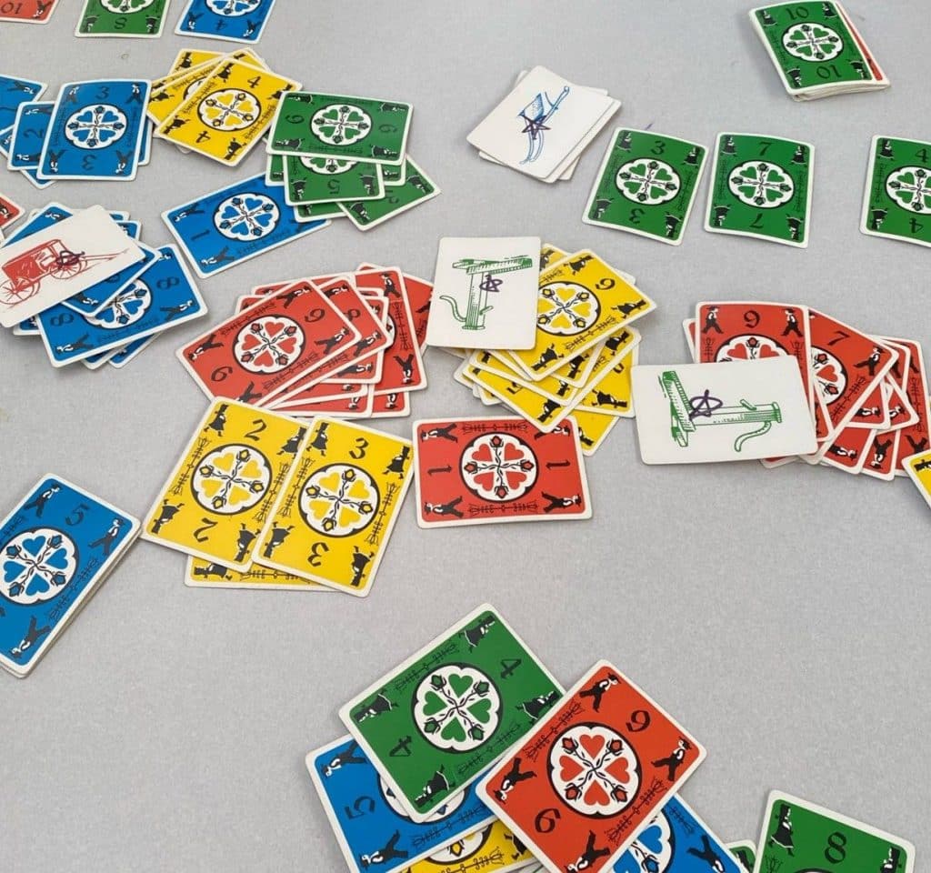 Multi-colored Dutch Blitz game cards scattered across a table.
