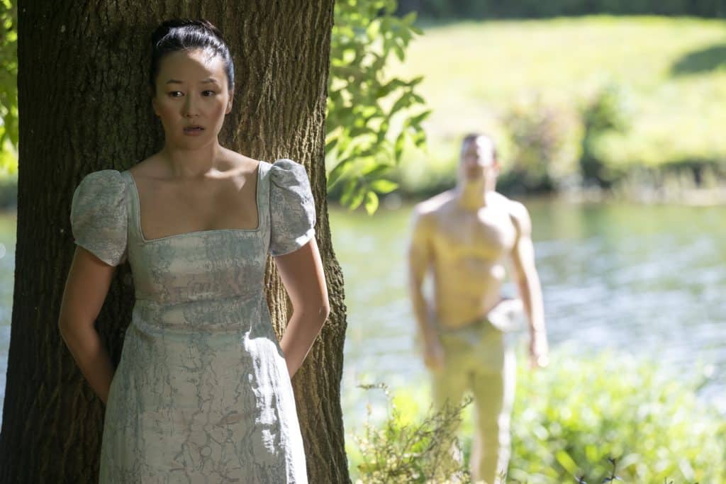 Sophie hides from a shirtless Benedict behind a tree.