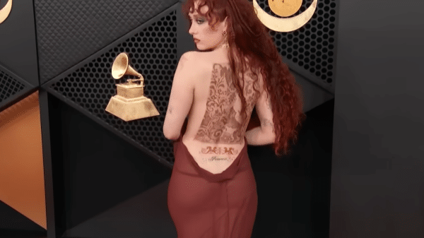 Chappell Roan poses for a photo on the carpet in her backless dress.