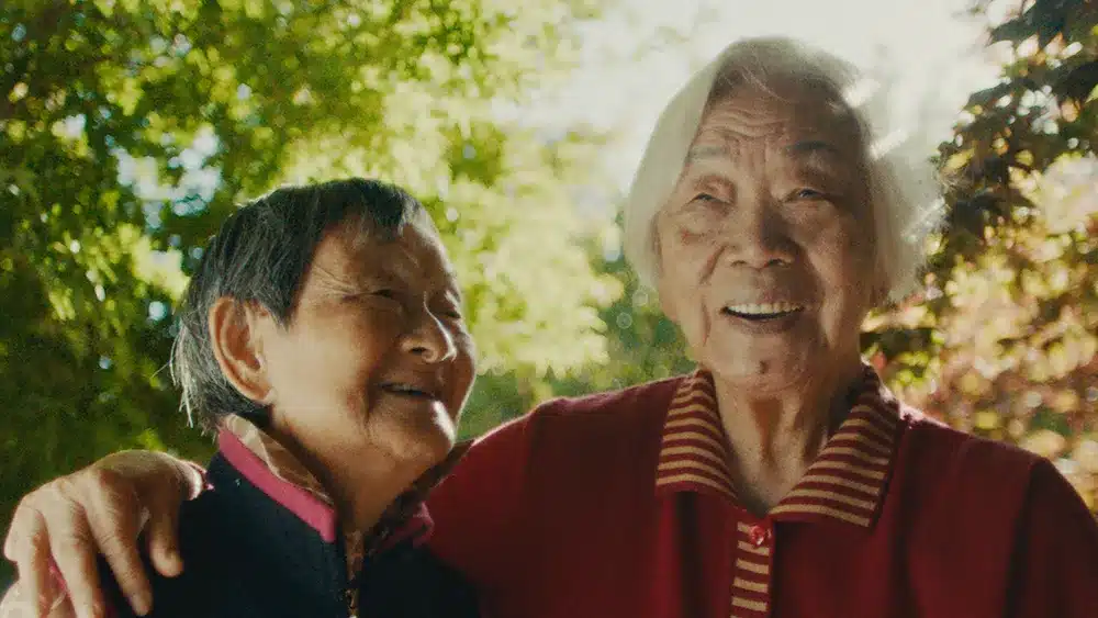 Two older women embrace.