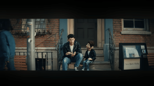 Nick Jonas sat on some steps outside of a building in his latest music video for Gut Punch