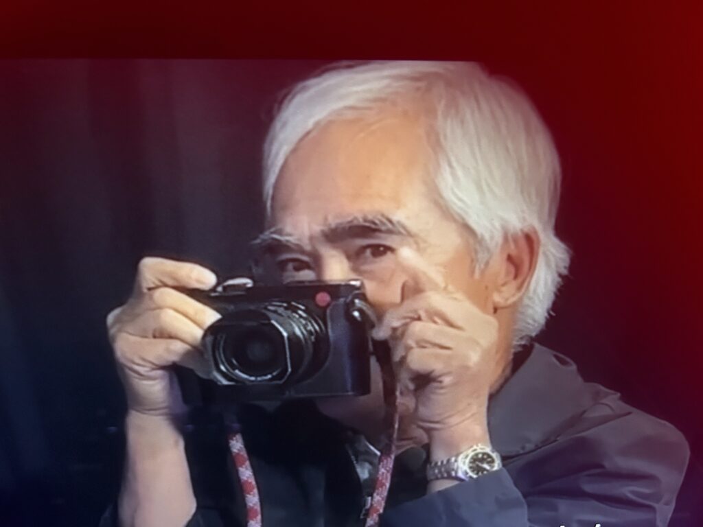 Nick Út holding a camera.