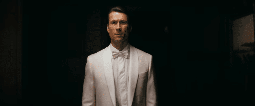 Becket Redfellow (Glenn Powell) in a white suit. Credit: YouTube/@A24