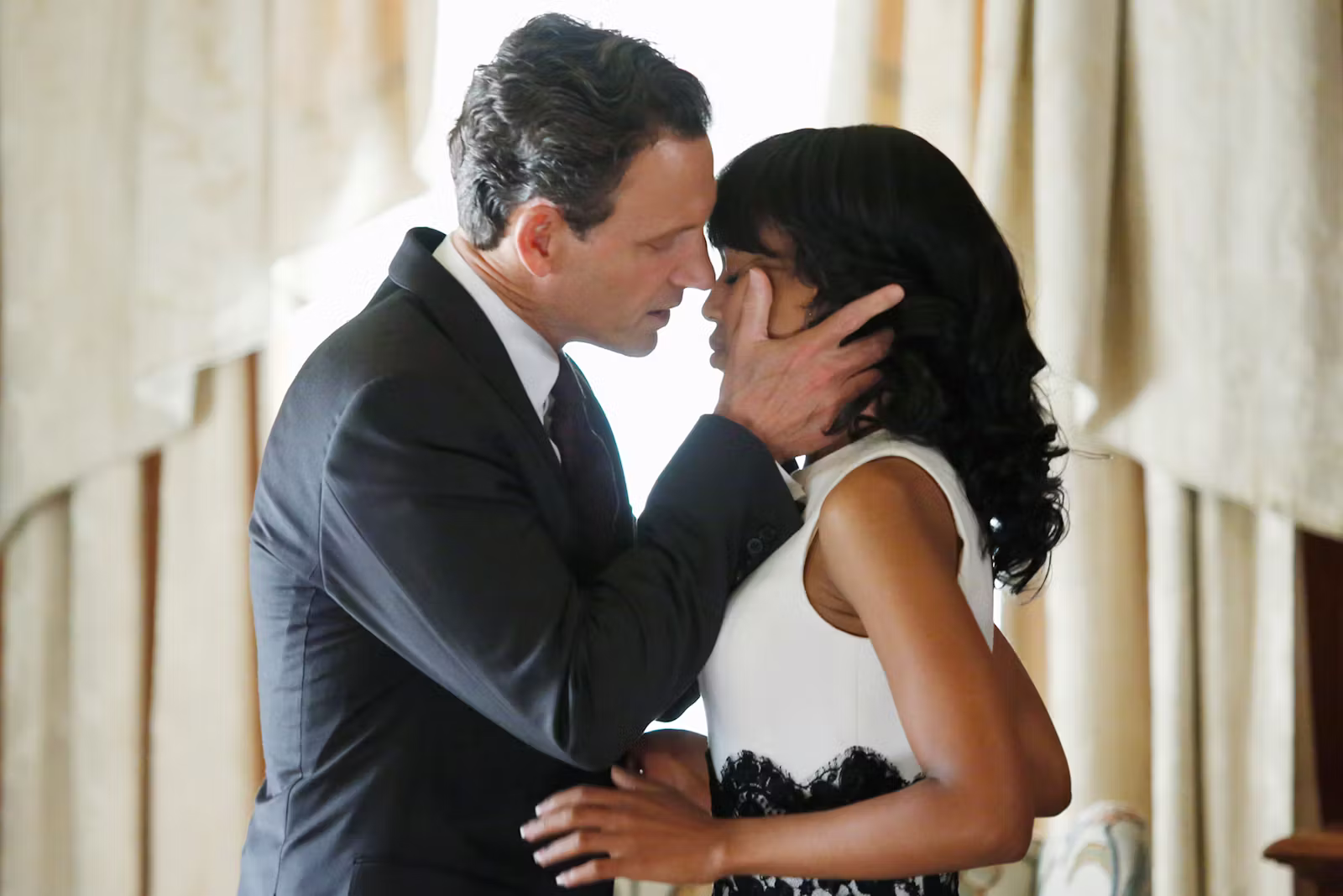 Fitz holds Olivia's face in his hands, about to kiss her.