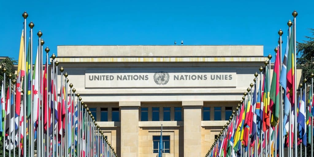 Image of United Nations building with country flags on the side.