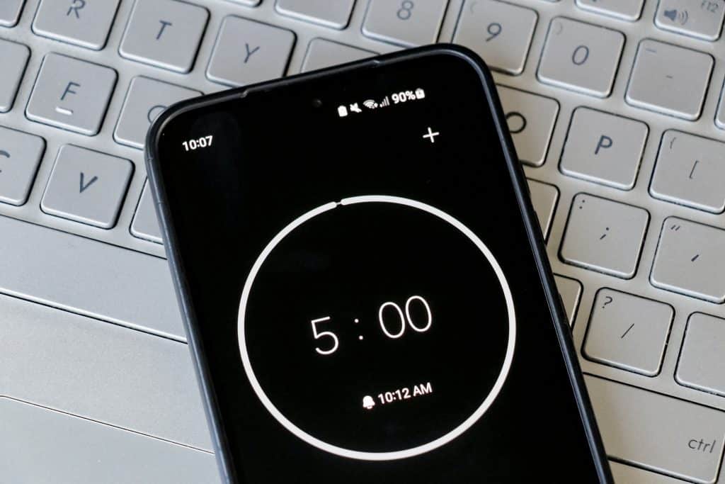 Phone laying on keyboard with a five minute timer on it.