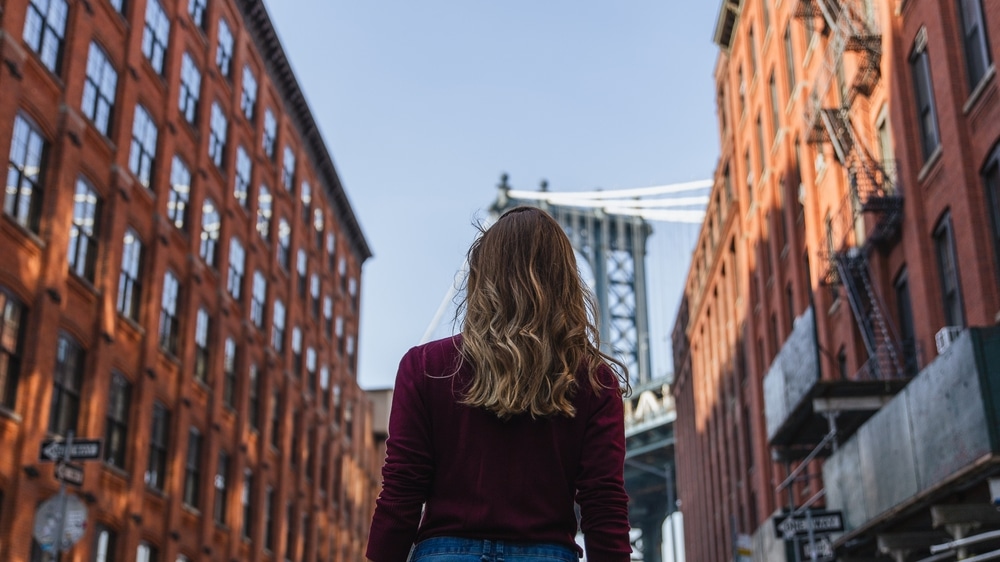 Image of woman looking at a big city with the camera angled behind her.