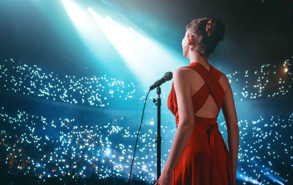 Woman pop star sings into a microphone