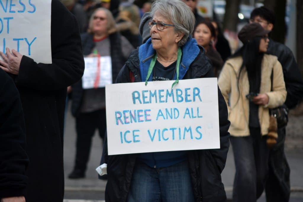 Person holding sign that says 'Remember Renee and all ICE Victims'