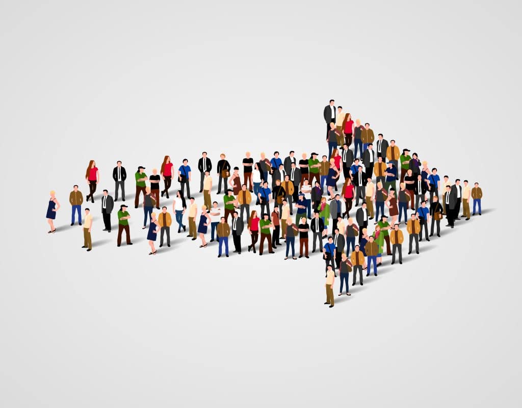 A large group of people, all genders from different backgrounds in a shape of an arrow on a white backdrop symbolising moving forward