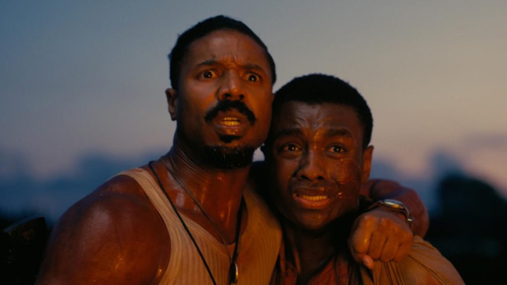 Michael B. Jordan and Miles Caton in character watching the vampires burst into flames.