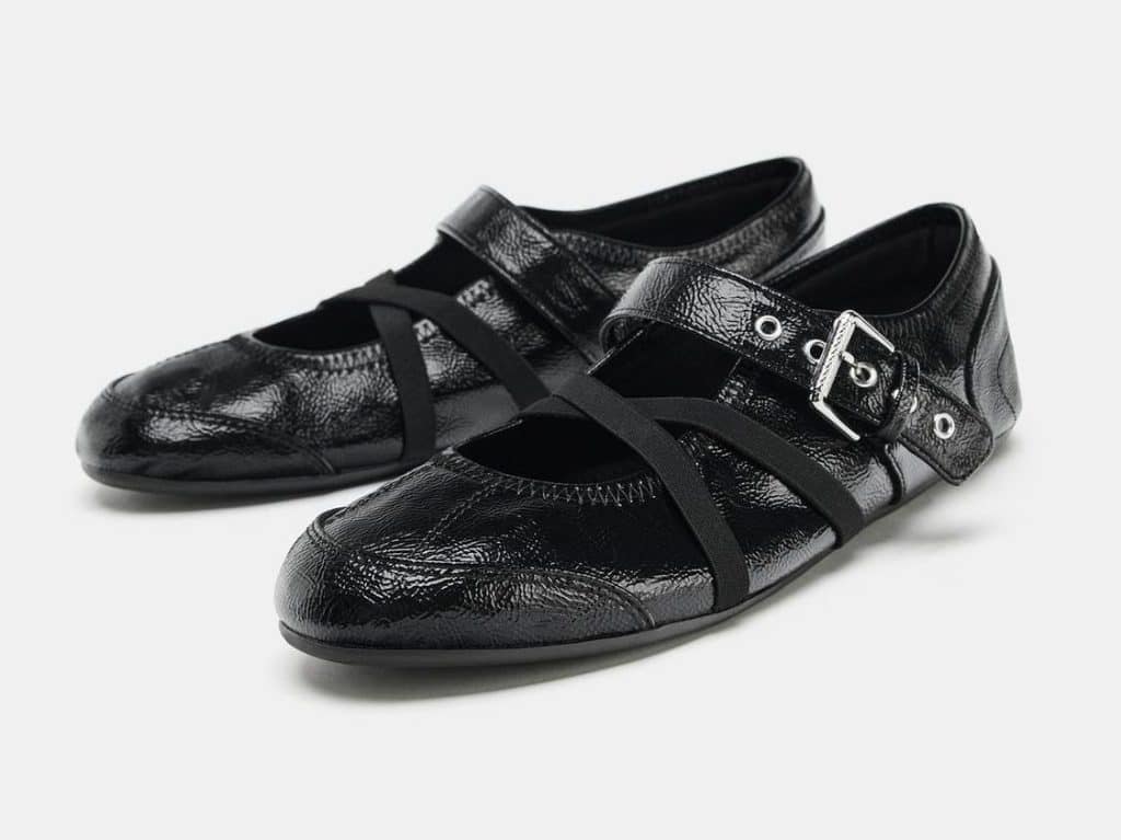 a pair of ballet flats with cross-crossed straps and a buckle
