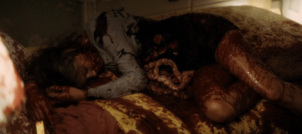 Screenshot from the fourth 'Scream' movie of a girl on a bed, covered in blood and disemboweled.