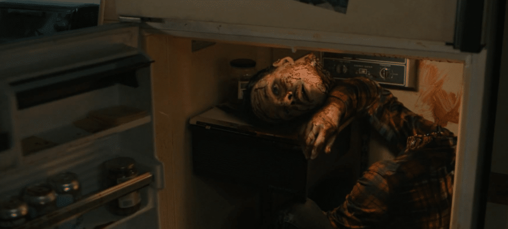 Screenshot from the sixth 'Scream' film of a decapitated head and body stuffed into a household fridge.