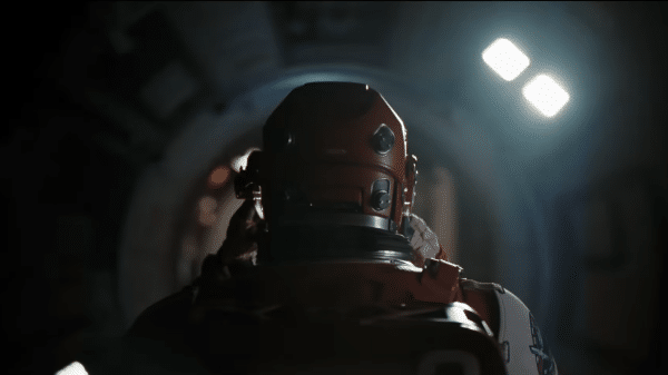 Screenshot from behind Ryland Grace putting his EVA suit on